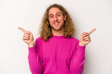 Beyaz arka planda izole edilmiş genç beyaz bir adam farklı kopya alanlarını gösteriyor, birini seçiyor, parmaklarıyla gösteriyor..