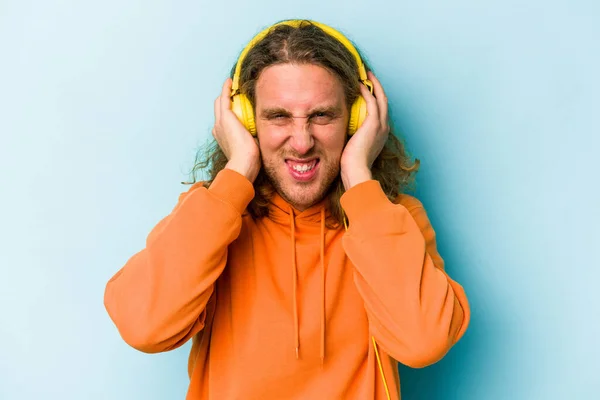 Joven Hombre Caucásico Escuchando Música Aislada Sobre Fondo Azul Cubriendo — Foto de Stock