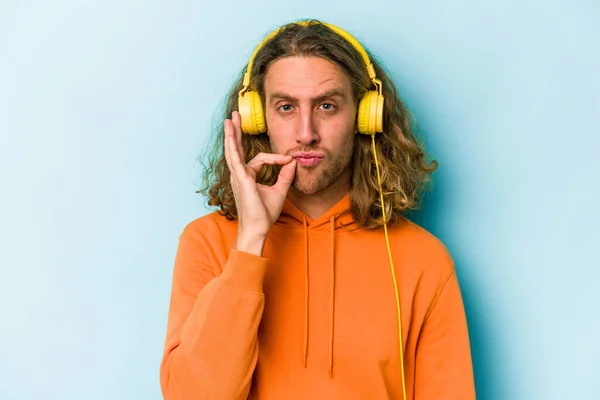Genç Beyaz Adam Mavi Arka Planda Izole Edilmiş Müzik Dinliyor — Stok fotoğraf