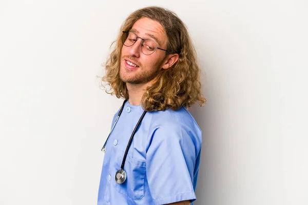 Young Nurse Caucasian Man Isolated Blue Background Looks Aside Smiling — Stock Photo, Image