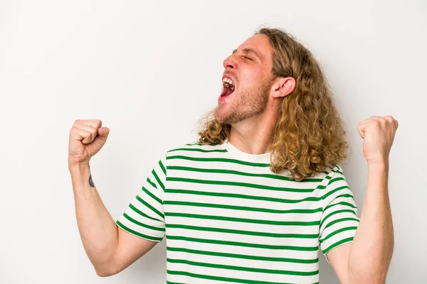 Beyaz arka planda izole edilmiş genç beyaz bir adam zaferden sonra yumruğunu kaldırıyor, kazanan konsept.