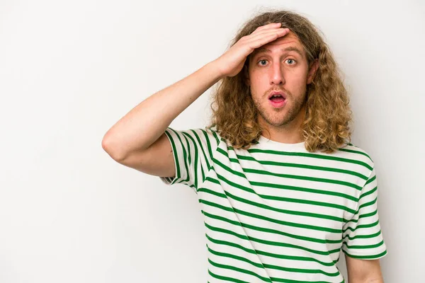 Beyaz arka planda izole genç beyaz adam yüksek sesle bağırıyor, gözleri açık ve elleri gergin tutuyor..