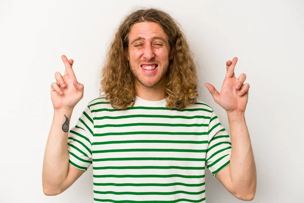 Beyaz arka planda izole genç beyaz adam şans dilemek için şans diliyor.