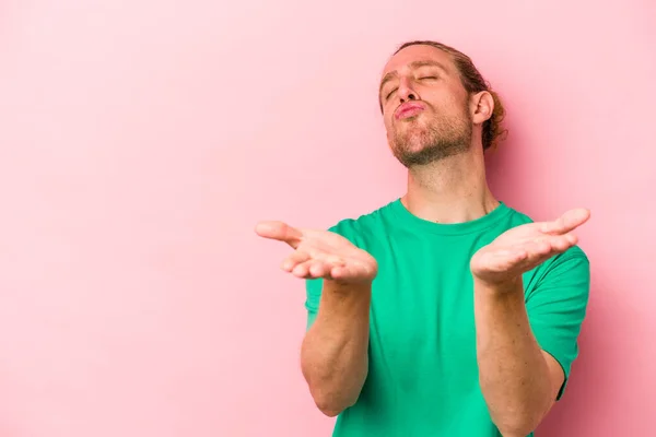 Jonge Blanke Man Geïsoleerd Roze Achtergrond Vouwen Lippen Handpalmen Lucht — Stockfoto