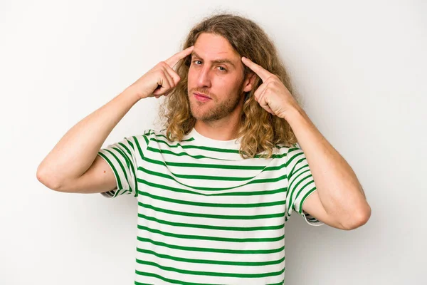 Beyaz arka planda izole edilmiş genç beyaz bir adam bir göreve odaklanmış, işaret parmaklarını işaret ediyor..