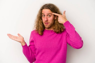 Beyaz arka planda izole edilmiş genç beyaz bir adam elinde bir ürün tutuyor ve.