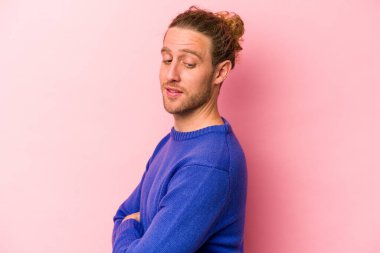 Genç beyaz adam pembe arka planda izole edilmiş gülüyor ve eğleniyor..