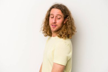 Beyaz arka planda izole edilmiş genç beyaz adam gülümseyen, neşeli ve keyifli bir tarafa bakıyor..