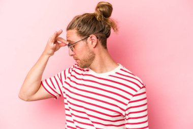 Kafkasyalı genç bir adam pembe arka planda izole edilmiş, başı ağrıyor, yüzüne dokunuyor..