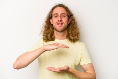 Beyaz arka planda izole edilmiş beyaz bir adam iki eliyle bir şey tutuyor..