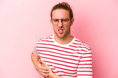 Pembe arka planda karaciğer ağrısı çeken, karnı ağrıyan genç beyaz bir adam..