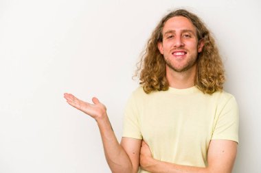 Beyaz arka planda izole edilmiş genç beyaz bir adam bir palmiye üzerinde fotokopi alanı gösteriyor ve belinde başka bir el tutuyor..