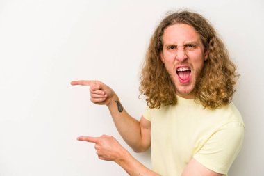 Beyaz arka planda izole edilmiş genç beyaz bir adam işaret parmağıyla işaret ettiği için heyecanlı..