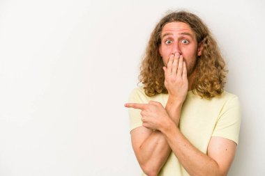 Beyaz arka planda izole edilmiş genç beyaz adam yan tarafı işaret ediyor