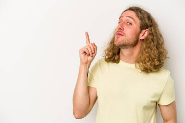 Beyaz arka planda izole edilmiş beyaz tenli genç bir adam bir numarayı parmağıyla gösteriyor..