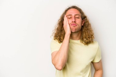 Beyaz arka planda izole edilmiş, üzgün ve dalgın hisseden genç beyaz bir adam fotokopi alanına bakıyor..