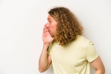 Beyaz arka planda izole edilmiş genç beyaz bir adam gizli bir sıcak fren haberi veriyor ve yana bakıyor.