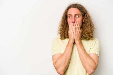 Beyaz arka planda izole edilmiş beyaz tenli genç adam ağzını eliyle kapatan bir fotokopi odasına bakıyor..