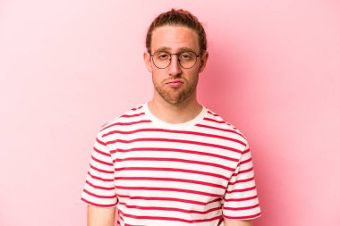 Pembe arka planda soyutlanmış beyaz bir adam üzgün, ciddi bir yüz, mutsuz ve hoşnutsuz..