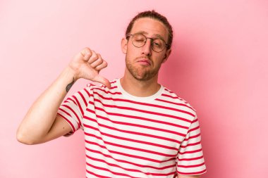 Pembe arka planda izole edilmiş genç beyaz bir adam hoş olmayan bir jest yapıyor. Anlaşmazlık konsepti.