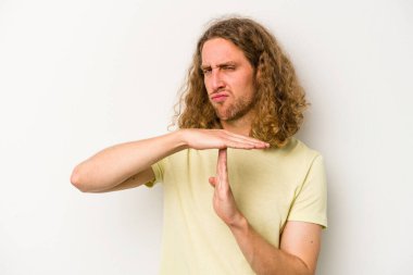 Beyaz arka planda izole edilmiş genç beyaz bir adam bir mola hareketi gösteriyor..