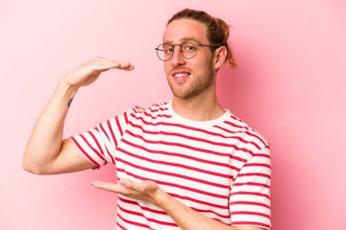 Pembe arka planda izole edilmiş beyaz bir adam iki eliyle bir şey tutuyor, ürün sunumu..