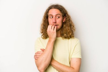 Beyaz arka planda izole edilmiş, tırnak yiyen, gergin ve endişeli genç bir beyaz adam..