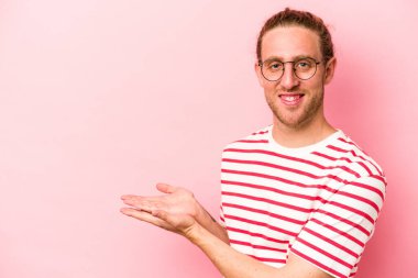 Pembe arka planda izole edilmiş beyaz bir adam elinde bir fotokopi odası tutuyor..