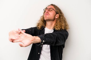 Beyaz arka planda izole edilmiş genç beyaz adam kollarını uzatıyor, rahat bir konumda..