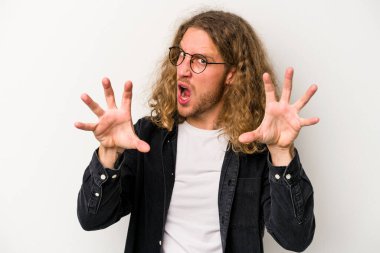 Beyaz arka planda izole edilmiş genç beyaz adam gergin elleriyle çığlık atıyor..