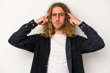 Beyaz arka planda izole edilmiş genç beyaz bir adam bir göreve odaklanmış, işaret parmaklarını işaret ediyor..