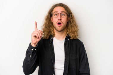 Beyaz arka planda izole edilmiş genç beyaz adam ağzı açık bir şekilde üst tarafı işaret ediyor..