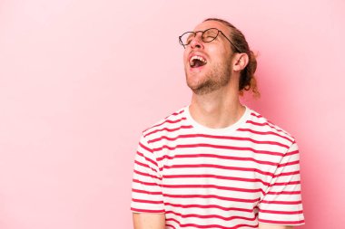Pembe arka planda izole edilmiş genç beyaz adam çok kızgın, öfkeli, hayal kırıklığına uğramış diye bağırıyor..