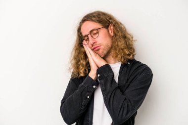 Beyaz arka planda izole edilmiş genç beyaz adam esniyor. Ağzı eliyle kapatan yorgun bir hareket sergiliyor..