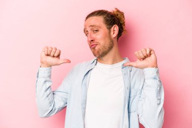 Pembe arka planda izole edilmiş genç beyaz adam gururlu ve kendinden emin hissediyor, örnek olarak.