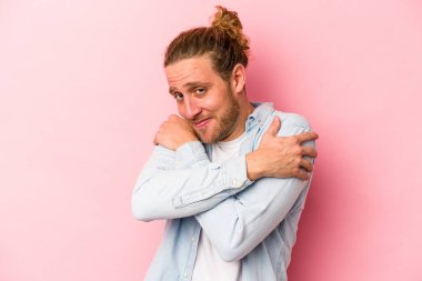 Kafkasyalı genç adam pembe arka planda izole edilmiş, güler yüzlü, kaygısız ve mutlu..