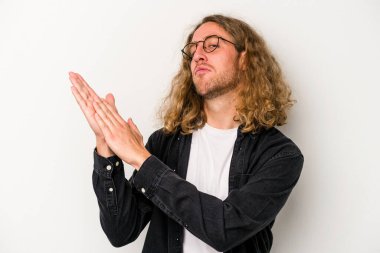 Beyaz arka planda izole olmuş genç beyaz bir adam enerjik ve rahat hissediyor, ellerini ovuşturuyor..