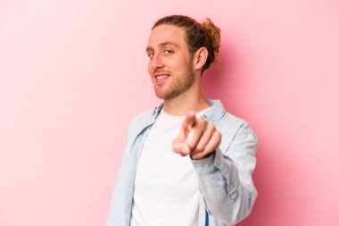 Pembe arka planda izole edilmiş genç beyaz adam. Önü işaret eden neşeli gülümsemeler..
