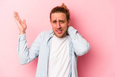 Pembe arka planda izole edilmiş genç beyaz adam öfkeyle bağırıyor..