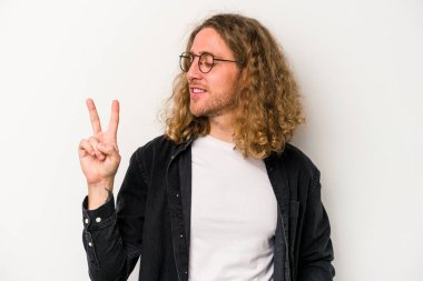 Beyaz arka planda izole edilmiş genç beyaz bir adam neşeli ve kaygısız parmakları olan bir barış sembolü gösteriyor..