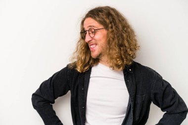 Beyaz arka planda izole genç beyaz adam mutlu bir şekilde gülüyor ve ellerini karnının üstünde tutarak eğleniyor..