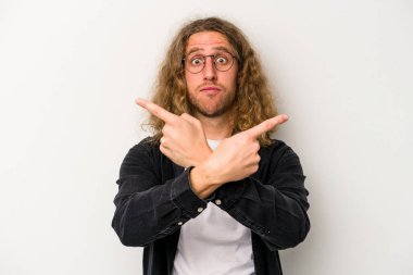 Beyaz arka plan noktalarında izole genç beyaz adam, iki seçenek arasında seçim yapmaya çalışıyor.