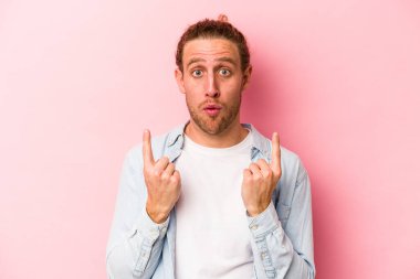 Pembe arka planda izole edilmiş beyaz bir adam ağzı açık bir şekilde üst tarafı işaret ediyor..