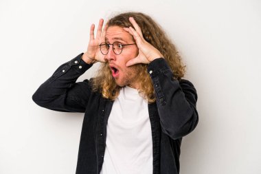 Beyaz arka planda izole edilmiş genç beyaz bir adam bir başarı fırsatı bulmak için gözlerini açık tutuyor..