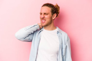 Genç, beyaz bir adam pembe arka planda izole edilmiş. Durağan yaşam tarzından dolayı boyun ağrısı çekiyor..