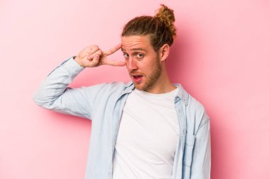 Genç beyaz adam pembe arka planda izole edilmiş dans ediyor ve eğleniyor..