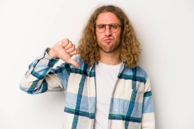 Beyaz arka planda izole edilmiş genç beyaz adam baş parmağını aşağı gösteriyor, hayal kırıklığı konsepti..