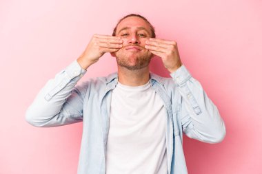 Pembe arka planda izole edilmiş beyaz bir adam iki seçenek arasında şüphe duyuyor..