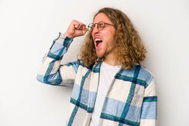 Beyaz arka planda izole edilmiş genç beyaz bir adam zaferi, tutkuyu ve coşkuyu kutluyor, mutlu bir ifade..