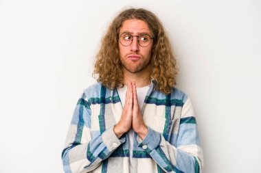 Beyaz arka planda izole edilmiş genç beyaz adam dua ediyor, bağlılık gösteriyor, dindar biri ilahi ilham arıyor..